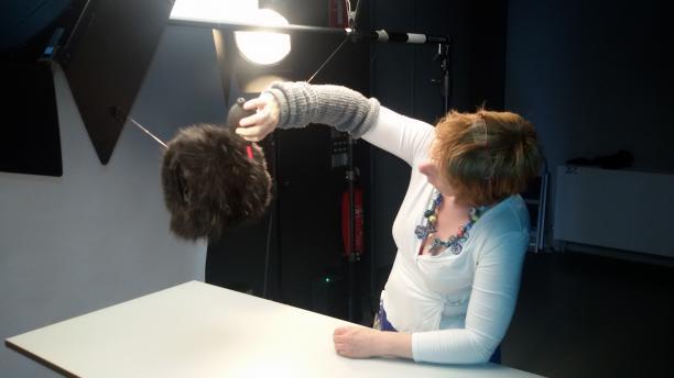 foto van een vrouw die een mof aan het styleren is in een fotostudio