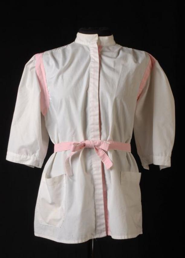 Kapsterjas, wit met roze accenten en los ceintuur, collectie Rotterdam