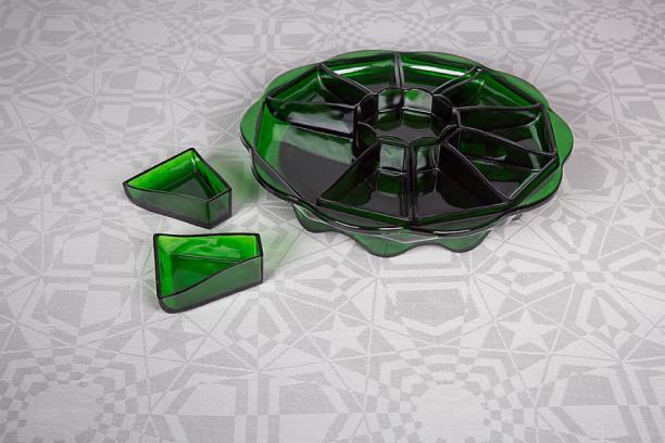 Damasten tafellaken ‘Stervariaties’(nr. 203), 1932, van Cris Lebeau, uitgevoerd door E.J.F. van Dissel, Eindhoven, 1932, met persglasservies van K.P.C. de Bazel, 1920. Foto: Josefina Eikenaar/ TextielMuseum.