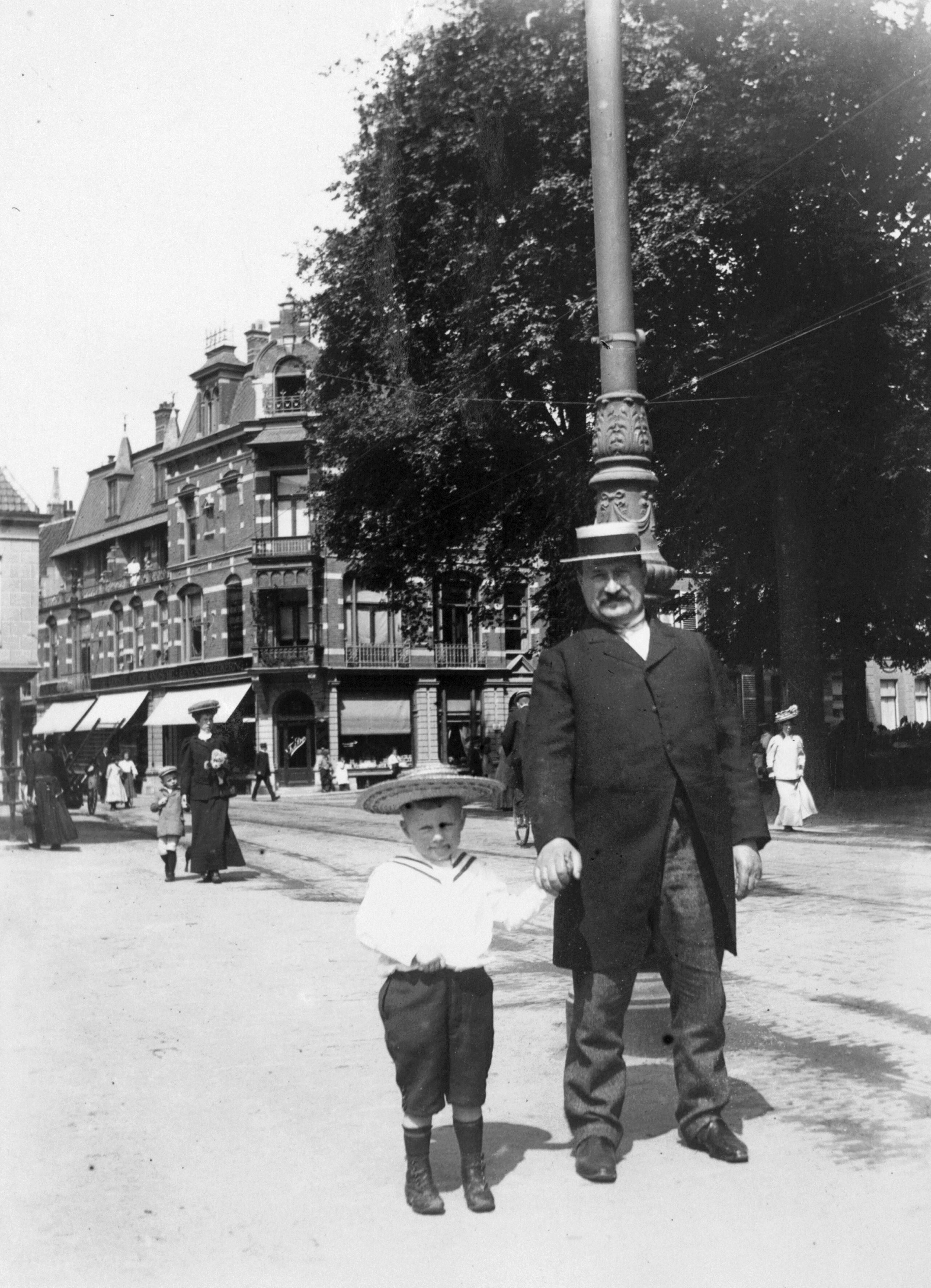Portret van man met zoontje in matrozenpak. (Foto Joh. A. Moesman, nr. 59447)