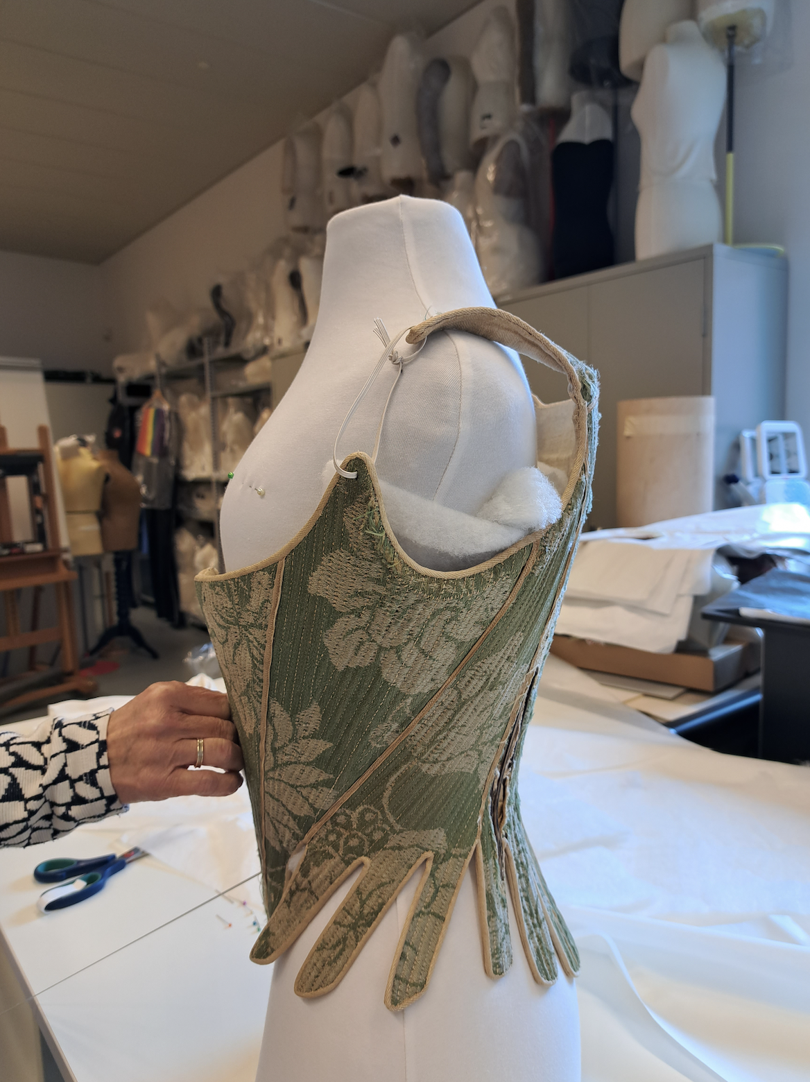 Zijaanzicht van het groene damast korset uit de collectie van het Zaans museum.