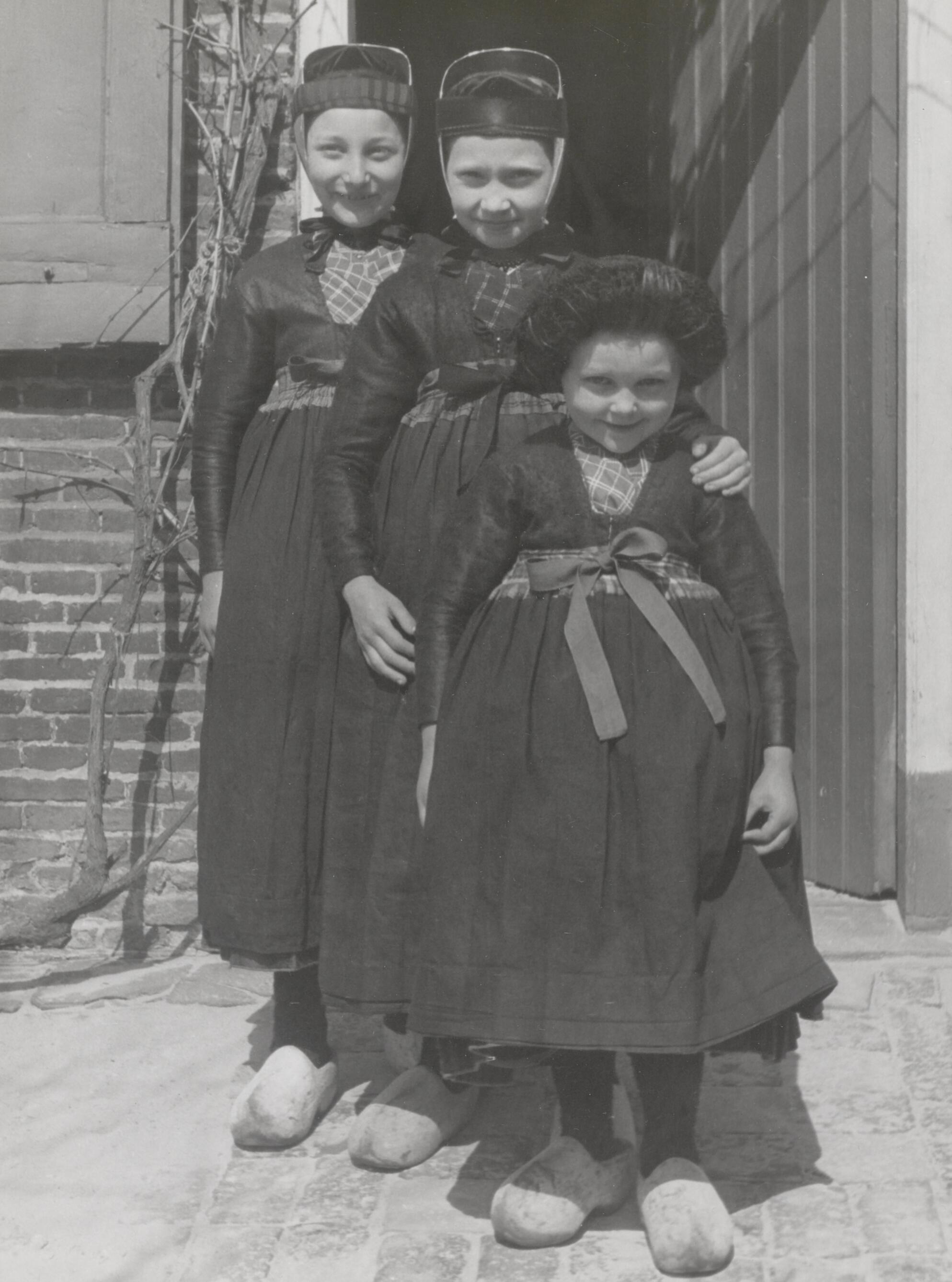 Drie meisjes met een 'buisje', het doordeweekse winterjak. Foto: Hans van Beelen, 1944. Bron: NOM