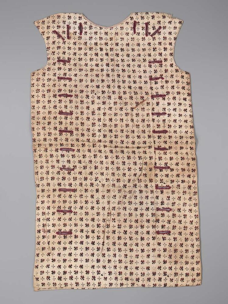 Een front van vest, witte wollige stof, bedrukt met bruin-rode bloemetjes, gevoerd met wit linnen