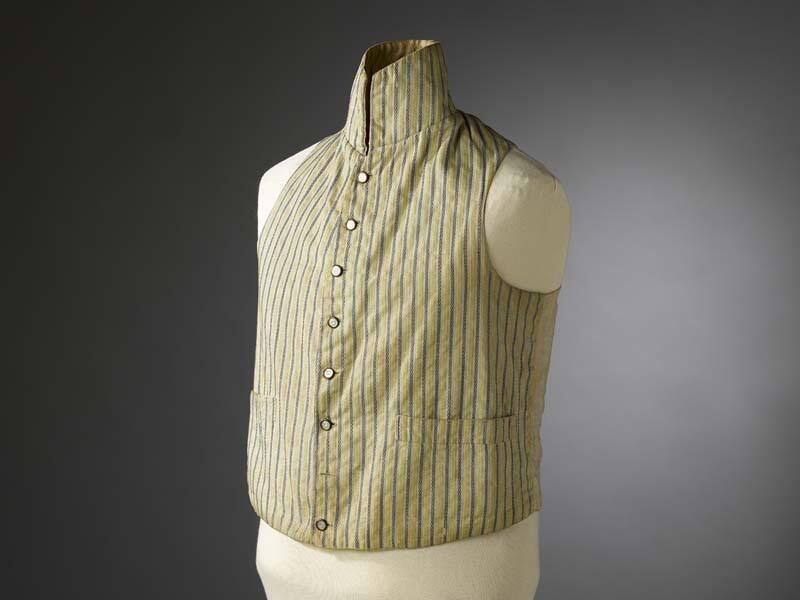 Mouwloos empire vest van gestreepte stof, geel en lichtblauw, hoge staande kraag, paarlemoeren…