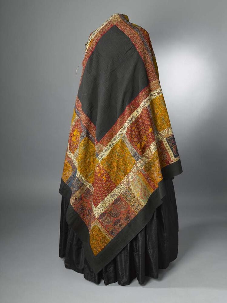 Omslagdoek in patchwork, met zwart vierkant middenveld, hier omheen blokken met kasjmierpatroon