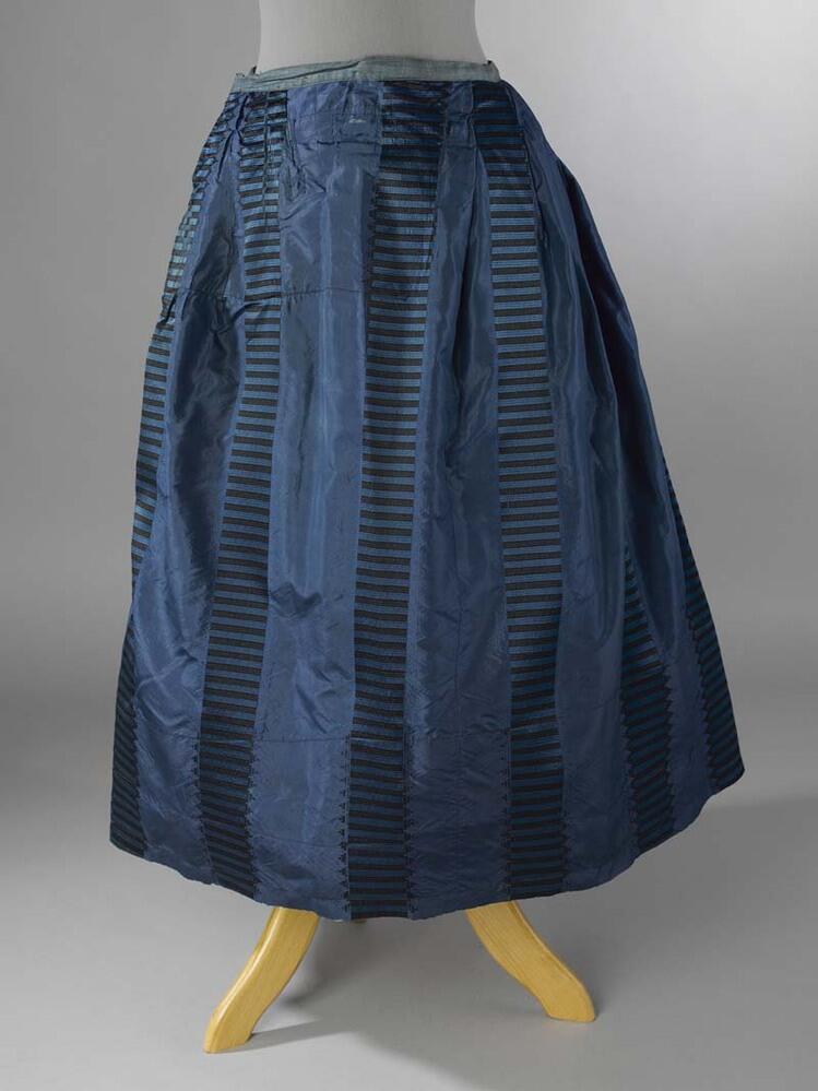 Rok van blauwe zijde met verticale banen van horizontale strepen blauw-zwart, 1 split