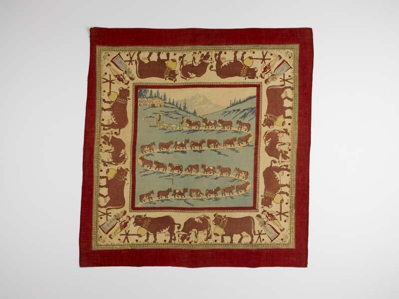 Souvenirdoek met bedrukte voorstelling van koeien in de Alpen, met rode rand