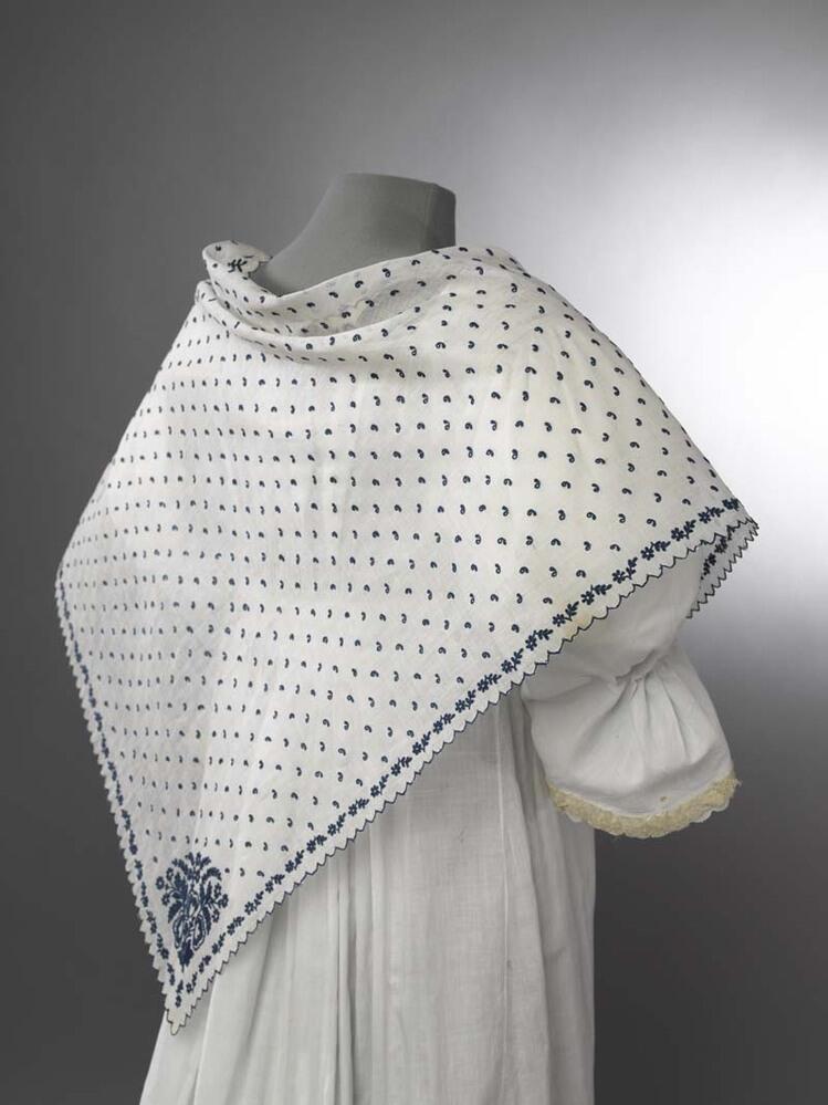 Fichu van neteldoek met bloemenrand  en bezaaid met strooimotiefjes van tamboureerwerk