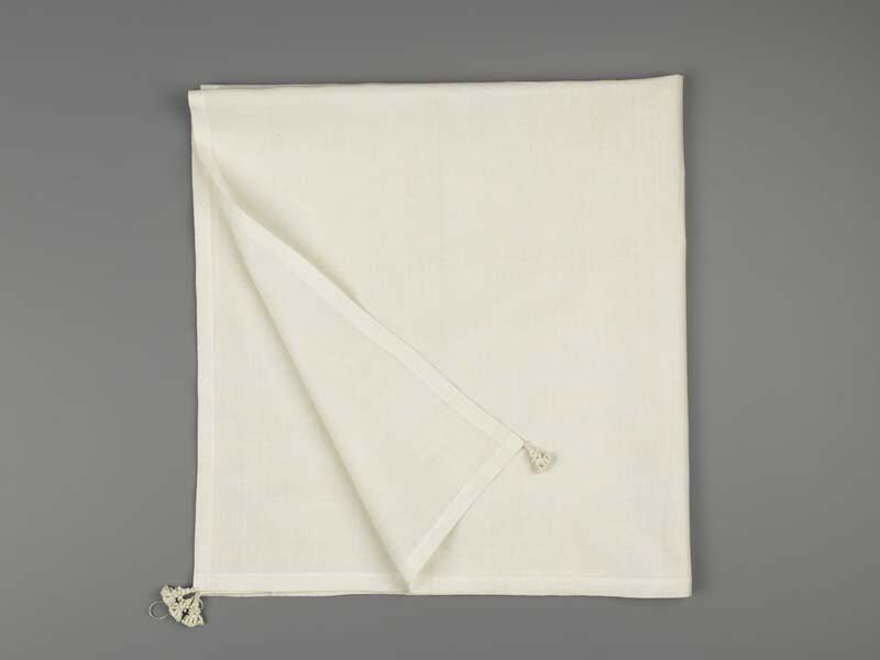 Halsdoek van wit linnen met 4 akertjes met in de linkeronderhoek de initialen M.T.