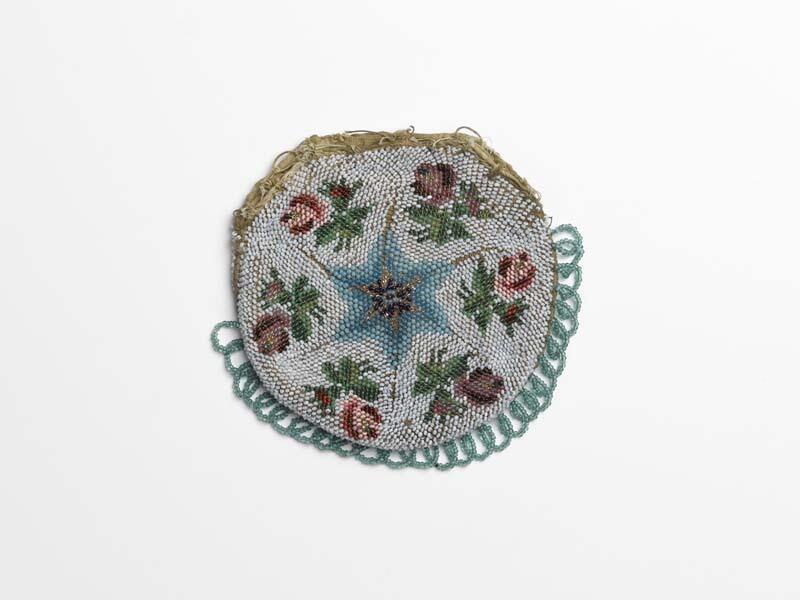Een rond beursje zonder beugel, met kralen gebreid en met franje van kralen, grijs fond, blauw ster…