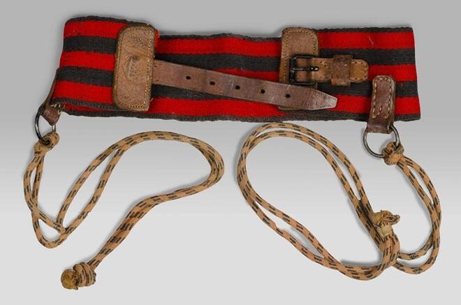 Kindertuigje met brede rood-zwarte wollen gordel van stevig band, leren riempjes met sluiting en…
