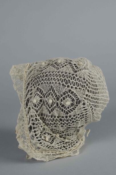 Ajourgebreid mutsje, binnengekomen met neteldoek mutsje