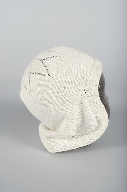 Wit katoenen muts recht, tricot, met stervormige bol gebreid, onderdeel van groep van twee