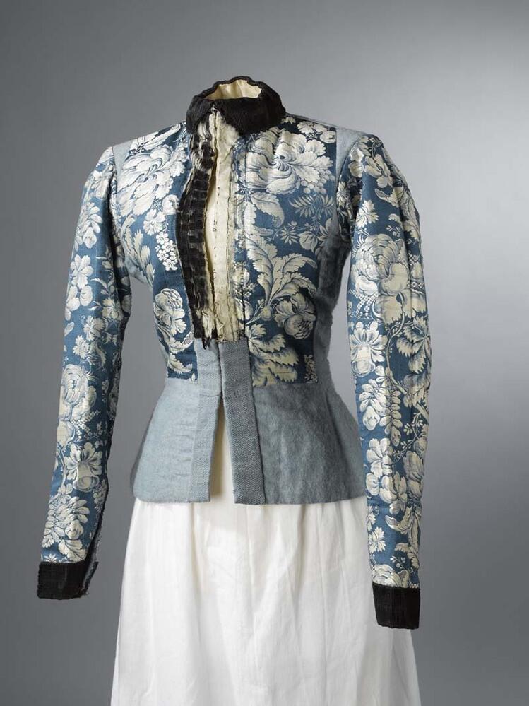 Onderst-oerlijf voor de winter, van lichtblauwe kalemink, (wollen satijn) met blauwe zijden…