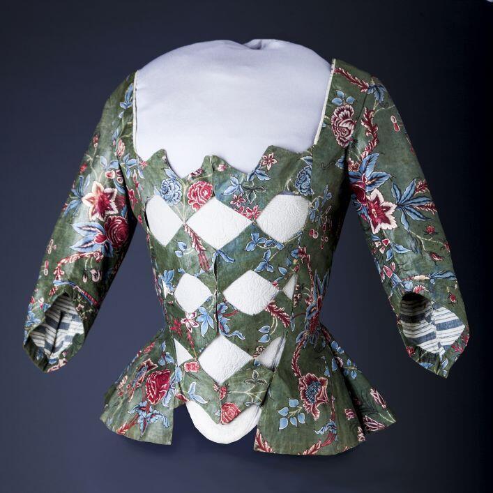 Sitsen vrouwenjak met zigzagvormige vestpandjes, met bloemmotieven op groene grond en blauw-wit…