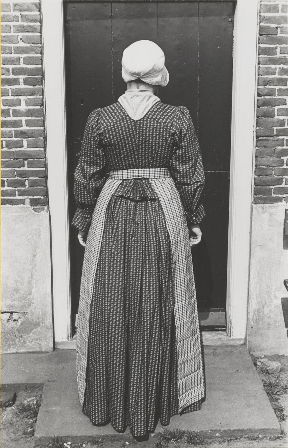 Vrouw verkleed in streekdracht, Huizen, 1945