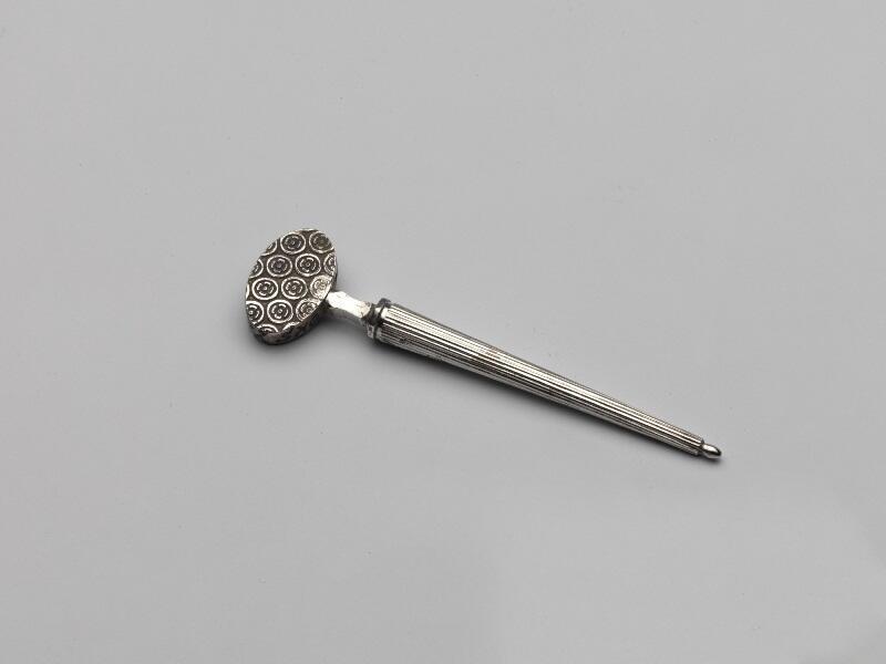 Zilveren naaipriem (of pijpenpluizer) met knop, in kokertje geschroefd met op het kokertje…