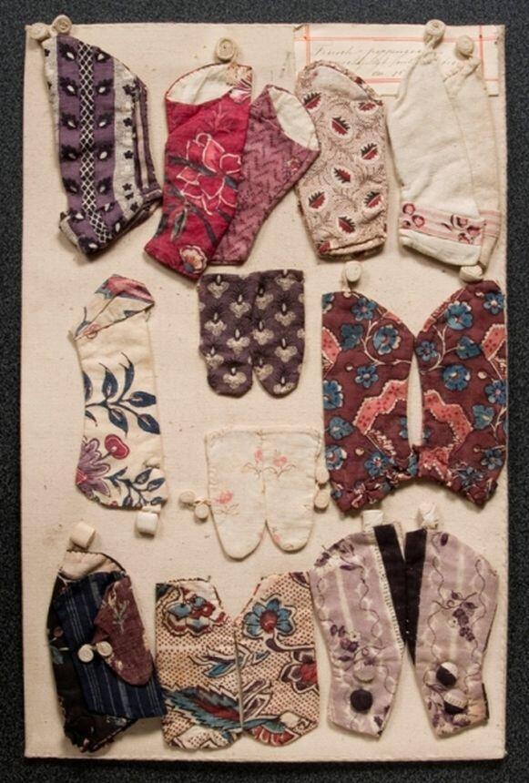 Paneel met mouwen uit eikenhouten kistje waarin zes panelen met 18de-eeuwse poppenkleding