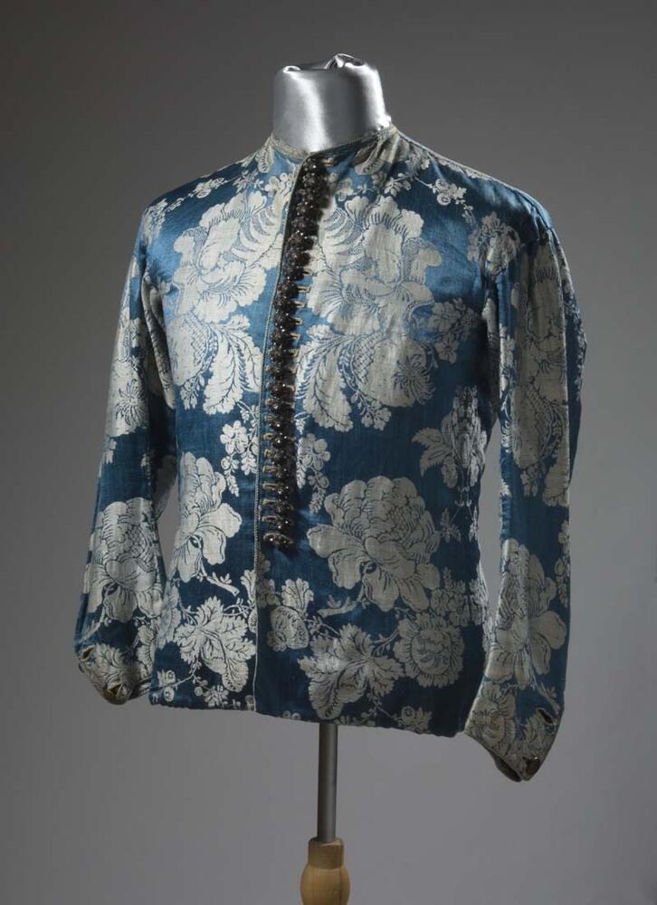Baeitje of mannenvest van blauwe damast met ingeweven witte bloemen, met aangenaaide zilveren…