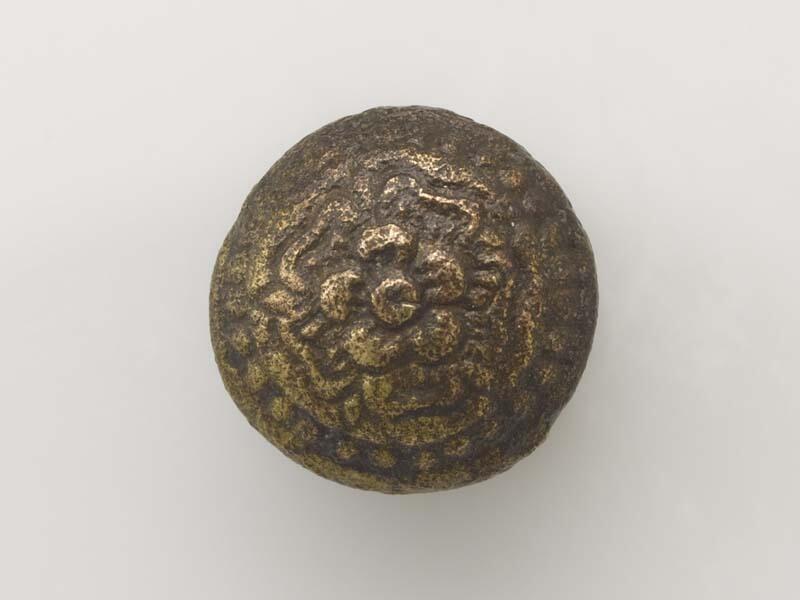 Ronde, bolle knoop met gladde contour en vijfbladig bloempje