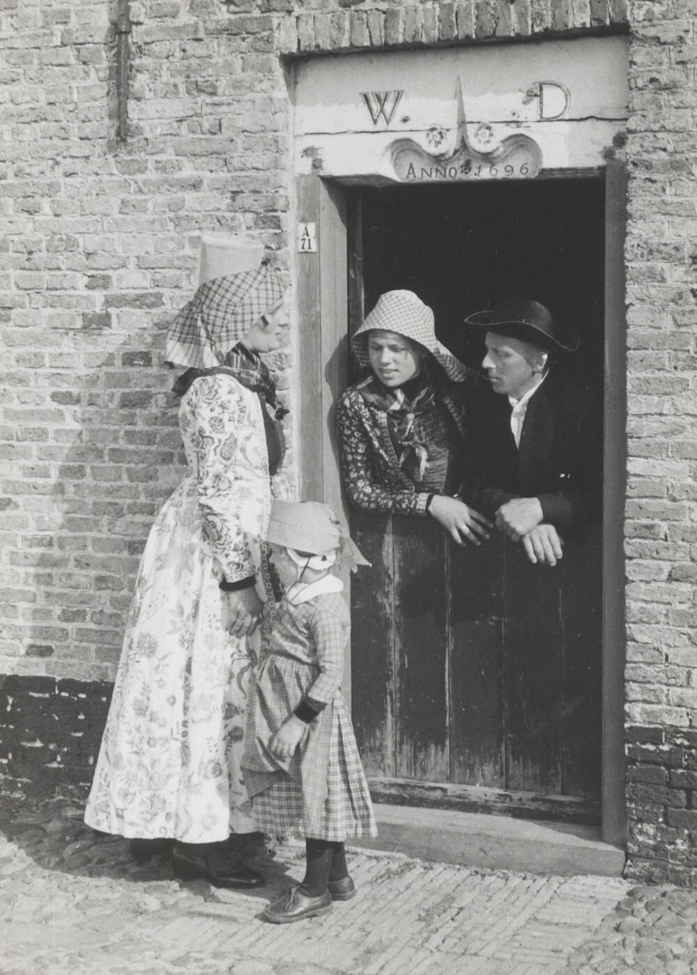 Vrouw, meisjes en man, verkleed in Hindelooper dracht, 1944