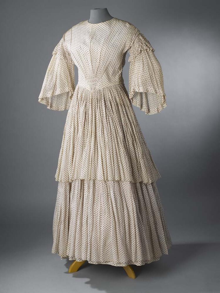 Crinolinejapon van mousselineachtige stof, bedrukt met kleine motiefjes in rood en blauw, wijde…