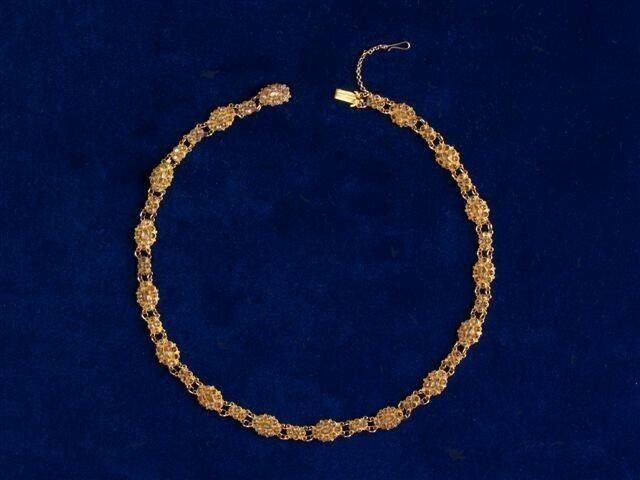 Fijn gouden ketting met op elke schakel een aantal groenige of gelige transparante steentjes