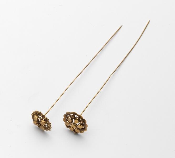 Gouden mutsspeld met rosetje en stampwerk