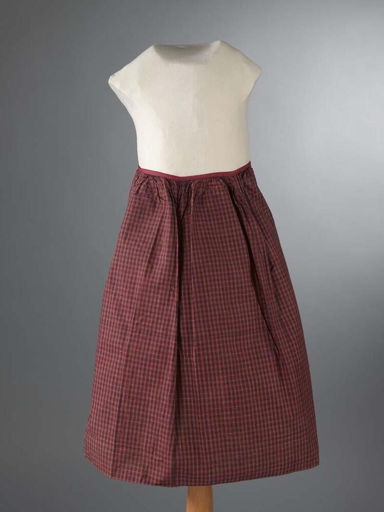 Hindelooper meisjesschort van rood-blauw-wit bont en met zijden kruissteek initialen GI