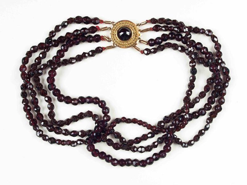 Collier van vier snoeren gefacetteerde granaatjes met gouden slot