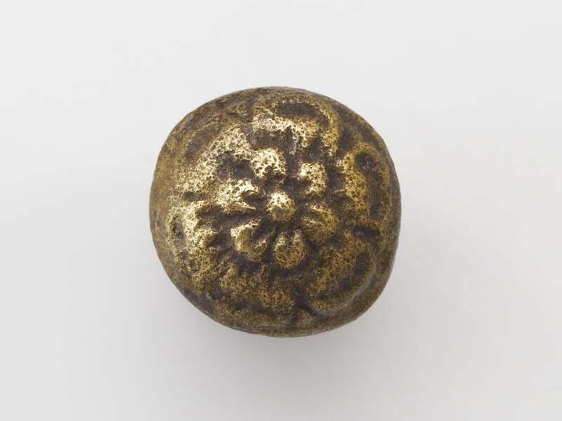 Ronde, bolle knoop met gladde contour en vijfbladig bloempje met hart