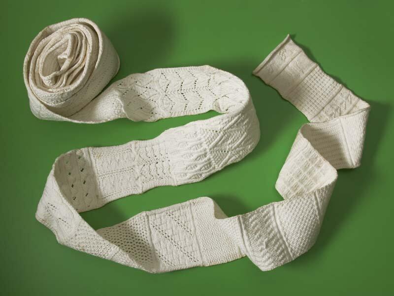 Breirol, ruim vijf meter lange en elf centimeter brede gebreide band van wit katoen, in diverse…
