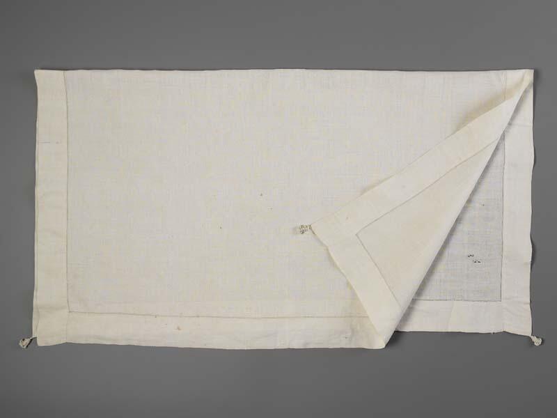Wit linnen halsdoek met initialen IS en akertjes aan de hoekpunten