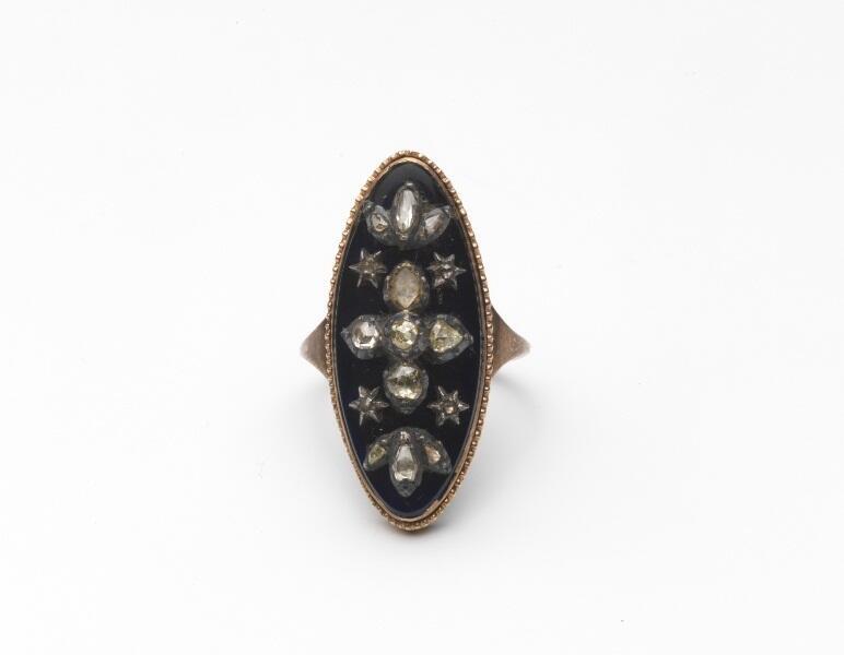 Gouden ring, zgn. marquisering, ovaal schild waarop blauw email fond, sterren en lelies van diamant…