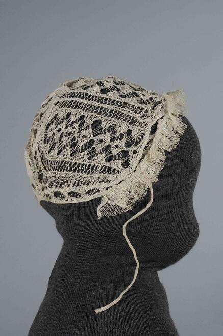 Ajourgebreid mutsje, binnengekomen met neteldoek mutsje