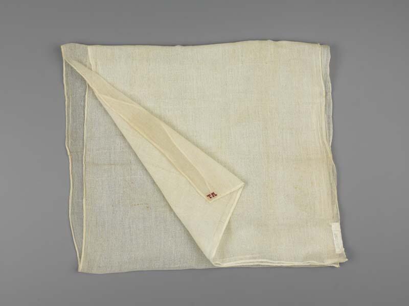 Een langwerpig sjaal van neteldoek, initialen T.A.