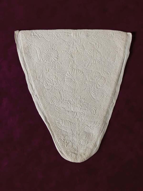 Driehoekige borstlap of stomacher van wit linnen met sierlijk bloemmotief in zaans stikwerk of…