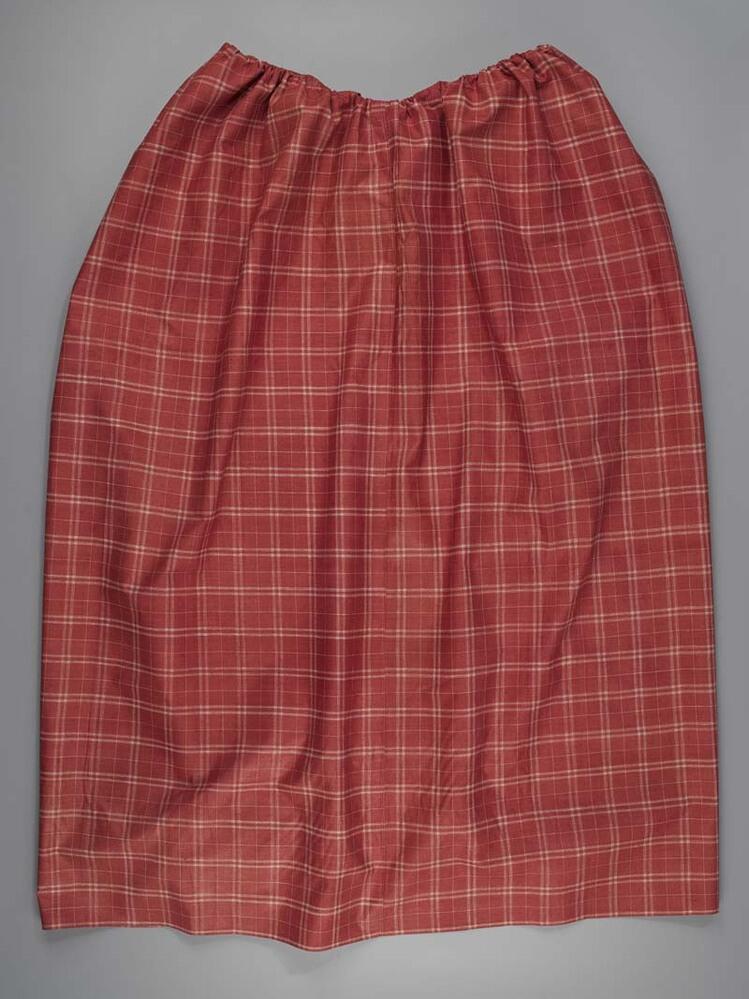 Schort van rood bont katoen met witte 'venster'ruiten, met veterband om schort te rimpelen