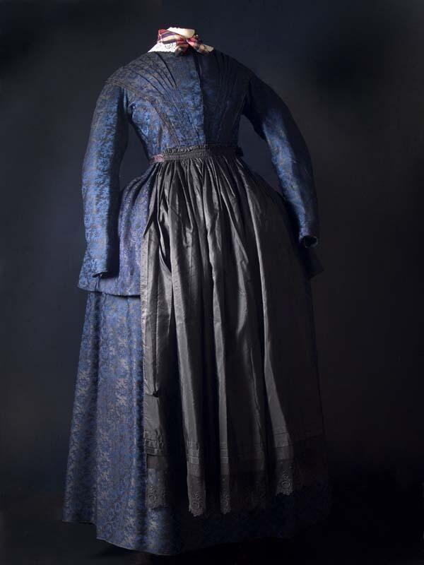 Kostuumjak met schoot van blauw-zwarte wol met ingeweven bloempatroon, geplooid voorpand en lage…
