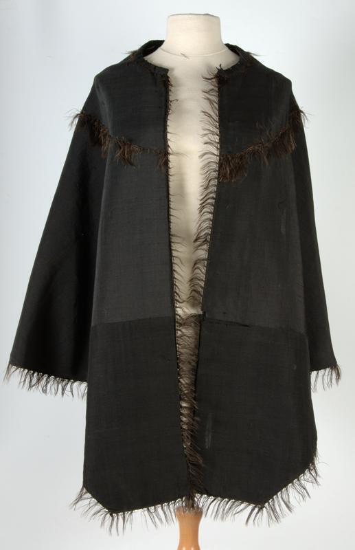 Schoudermantel van zwart mohair met franje, gevoerd met zwarte wol met witte plukjes, 'omgekeerd…