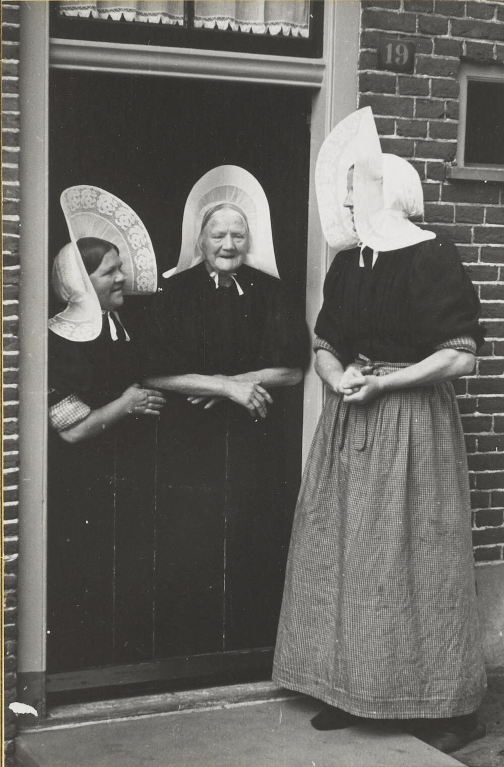 Drie vrouwen in streekdracht, Huizen, 1945