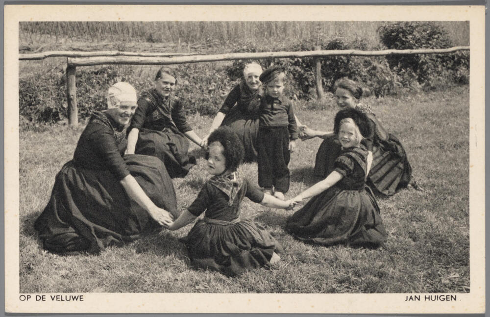 Groep in Veluwse streekdracht, spelende een kringspel