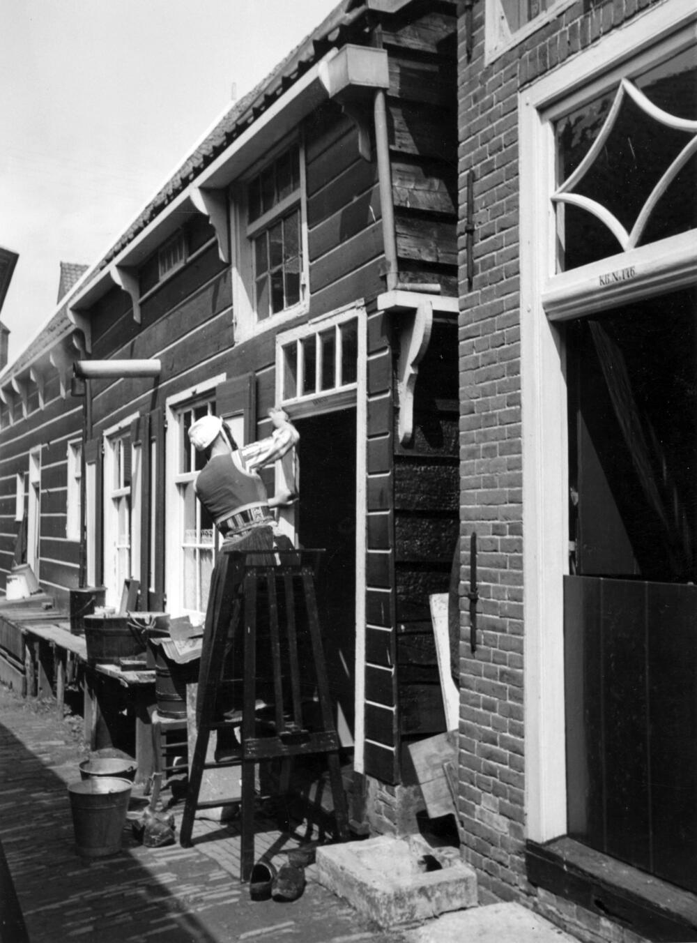 Vervende vrouw bij visserswoningen, Marken, 1943