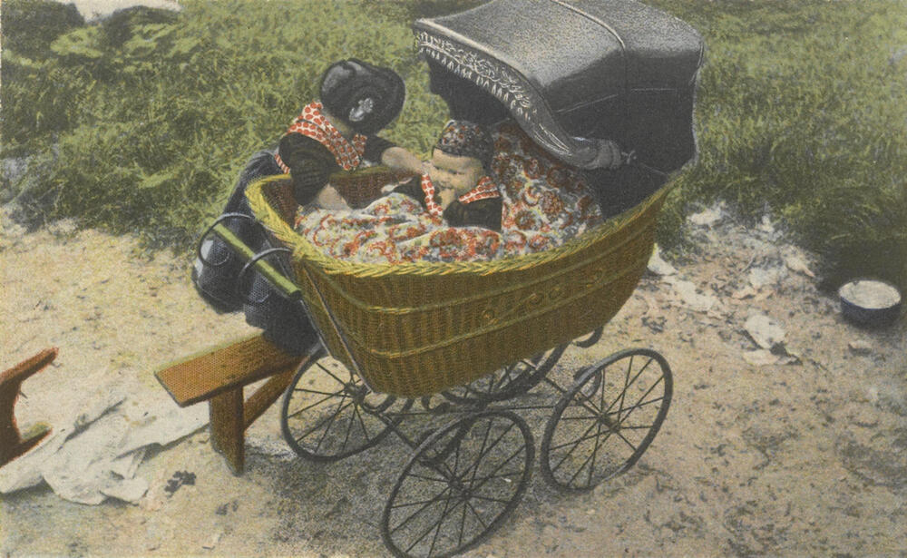 Twee meisjes in Staphorster streekdracht, met kinderwagen