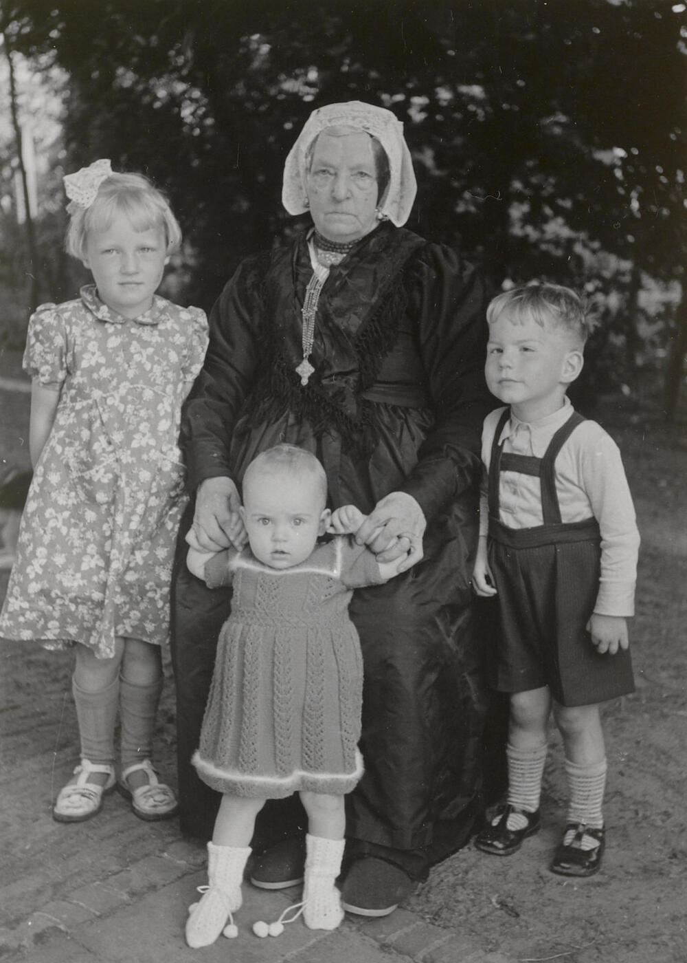 Geertruida van den Hoven in streekdracht uit Eemnes en drie kinderen, 1952