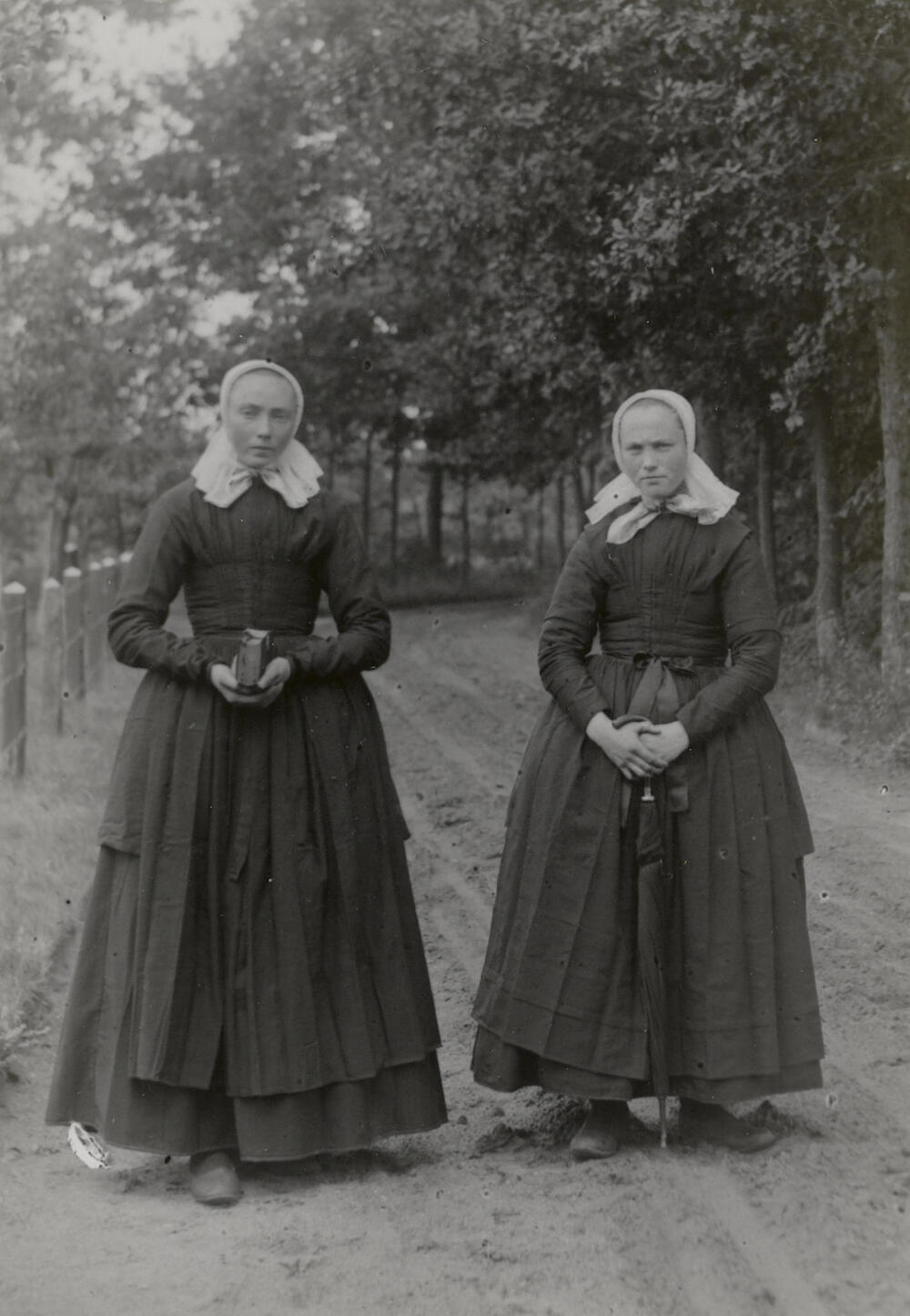Jennigje Oudelaar en Hendrikje Gerridina Pastink uit Den Ham op weg naar de kerk, 1899