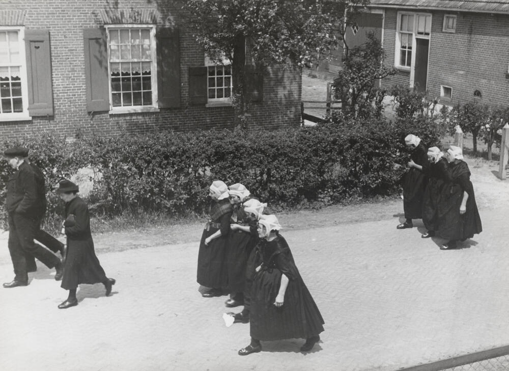 Mannen en vrouwen in zondagse kerkdracht, Staphorst, 1944
