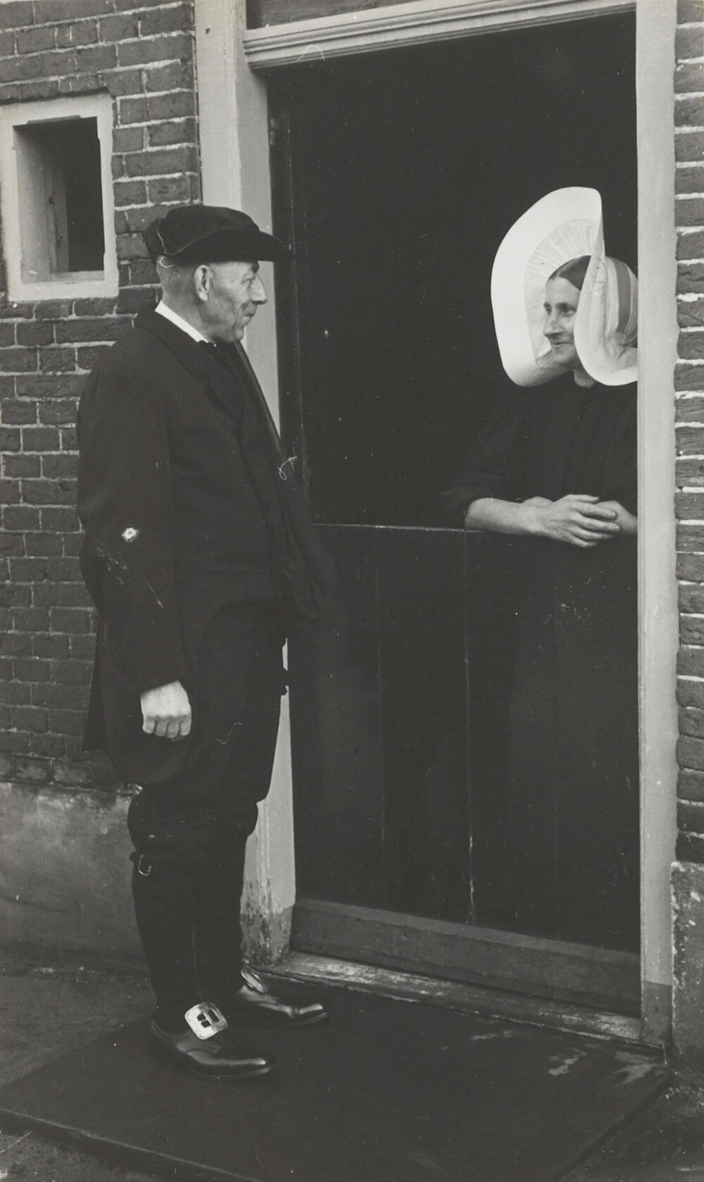 Man in aansprekerskostuum en vrouw in streekdracht, Huizen, 1945