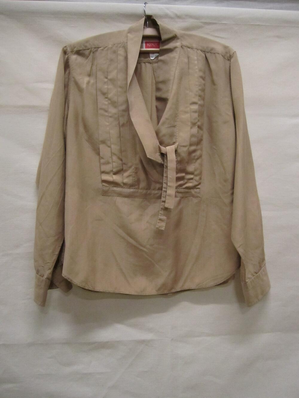 Blouse van beige zijde met 'plastron' van platte plissés middenvoor