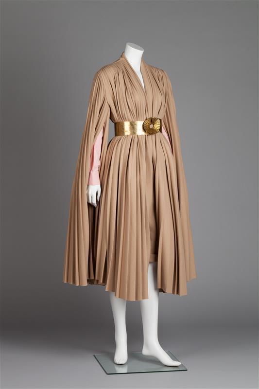 Cape met plissé, korte broek, losse mouwen en ceintuur